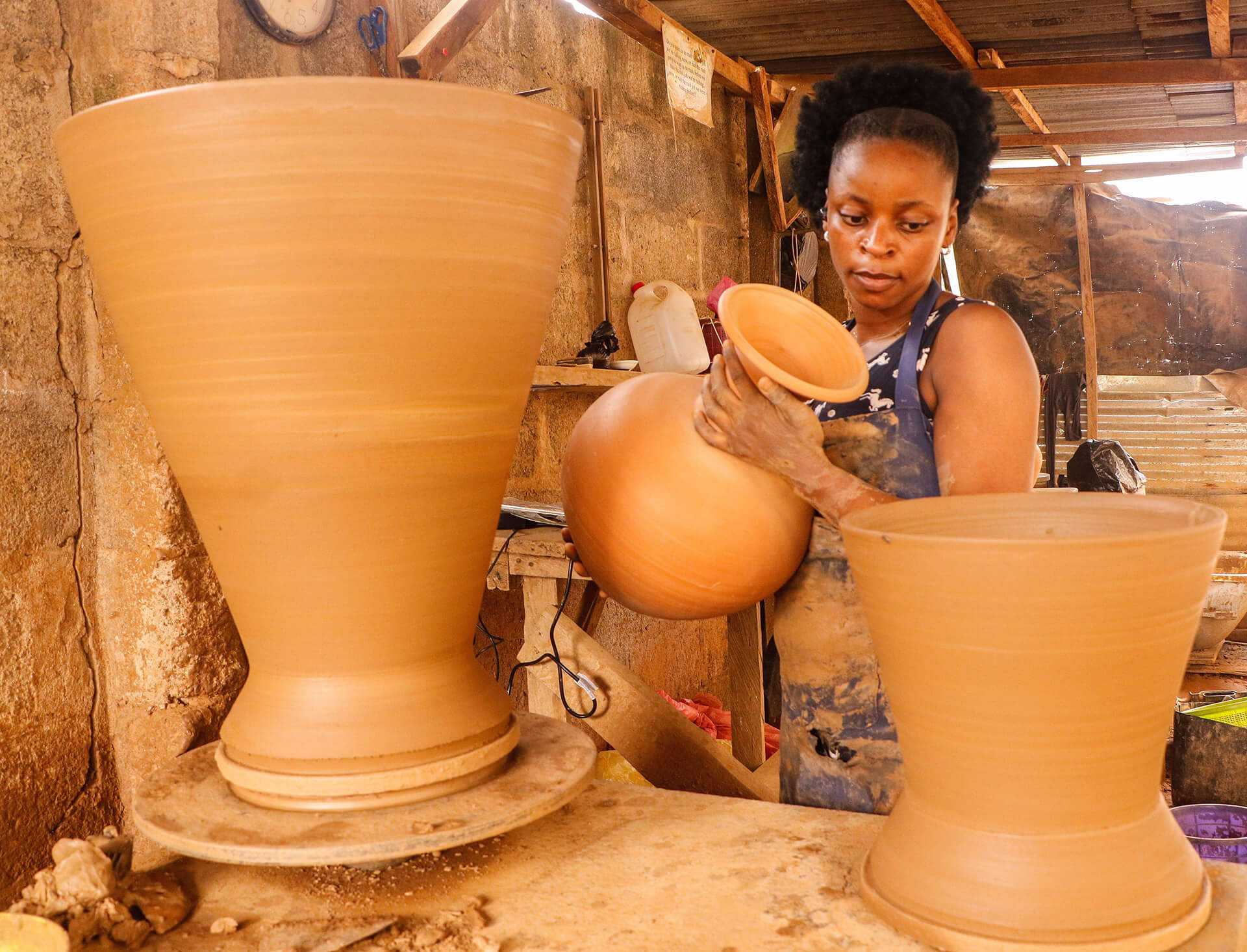 Craftswoman Olugbade Adekemi makes clay pots using traditional methods at her local pottery workshop in a suburb of Lagos.